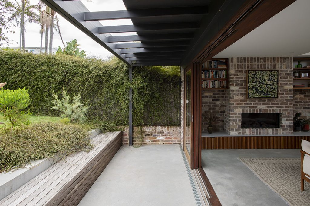 Indoor/outdoor living areas separated by an open stacker sliding door in Spotted Gum.